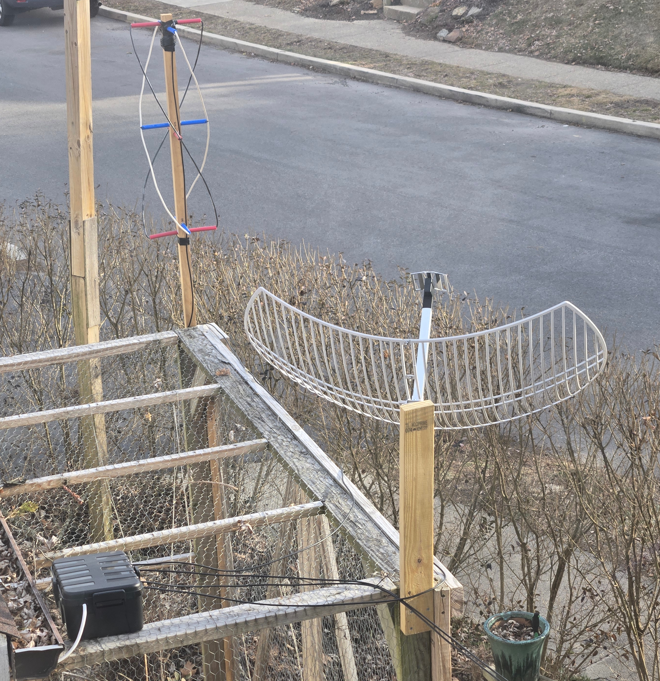 Here you can see the antennas mounted (over my tomato enclosure) and a nifty waterproof project box housing the low noise amplifiers near the antennas before being routed out of frame towards the house.